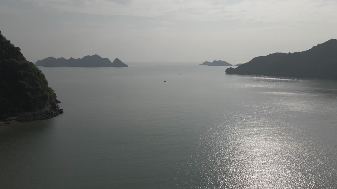 antena alta del océano: el sol plateado se refleja en el agua brumosa en la bahía de ha long