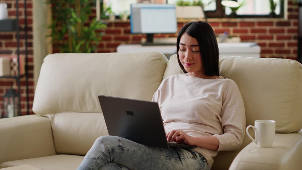 Woman working on laptop at home with coffee
