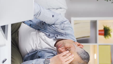 Vertical-video-of-Man-working-on-laptop-has-a-headache.