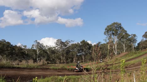 dirt bike riders compete on a natural track