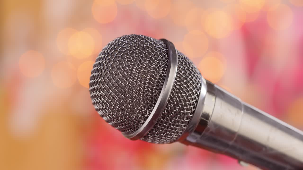 Microphone on stage against a blurry light ,blurry background.