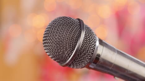 microphone on stage against a blurry light ,blurry background.