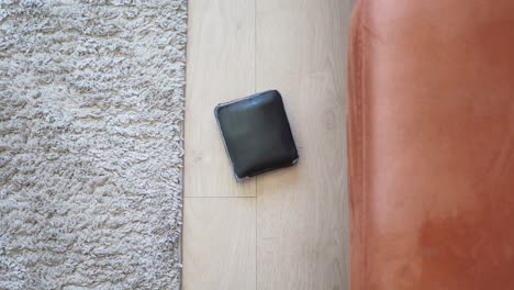 black leather wallet on the floor of a living room