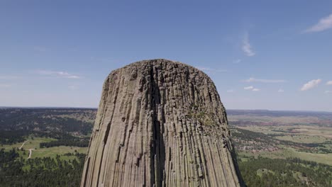 A-drone-shot-of-Devils-Tower,-a-massive,-monolithic,-volcanic-stout-tower,-or-butte,-located-in-the-Black-Hills-region-of-Wyoming