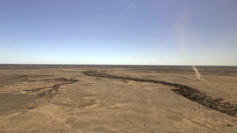 a dust devil whirls through the australian outback with a birds eye view from a drone