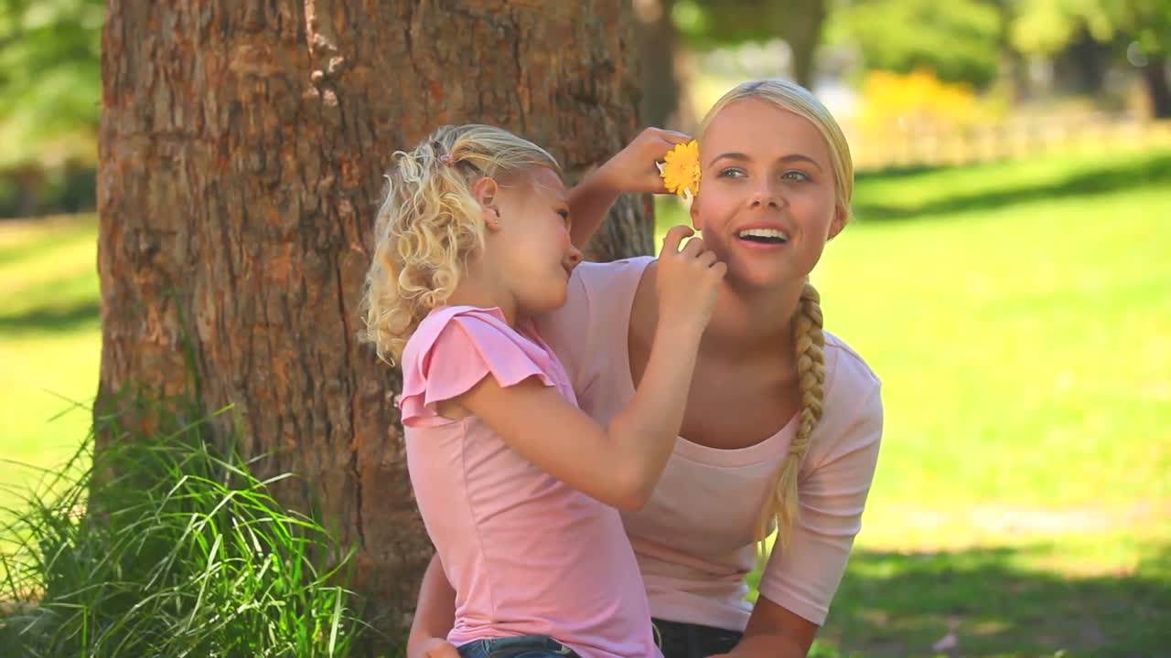 Junges Mädchen gibt ihrer Mutter eine Blume