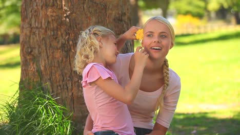 niña dando una flor a su madre