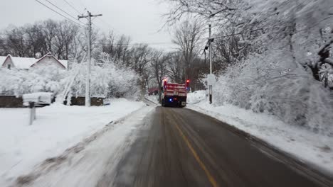 Aerial-view-following-a-plow-truck-through-a-twisty-hilly-road-after-a-heavy-snow-storm-near-a-cemetary