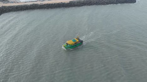 Toma-Aérea-De-Arriba-Hacia-Abajo-De-Un-Barco-De-Pesca-Que-Viaja-Hacia-El-Puerto-Desde-El-Mar-Por-La-Noche,-Filmada-Con-Un-Dron-En-4k