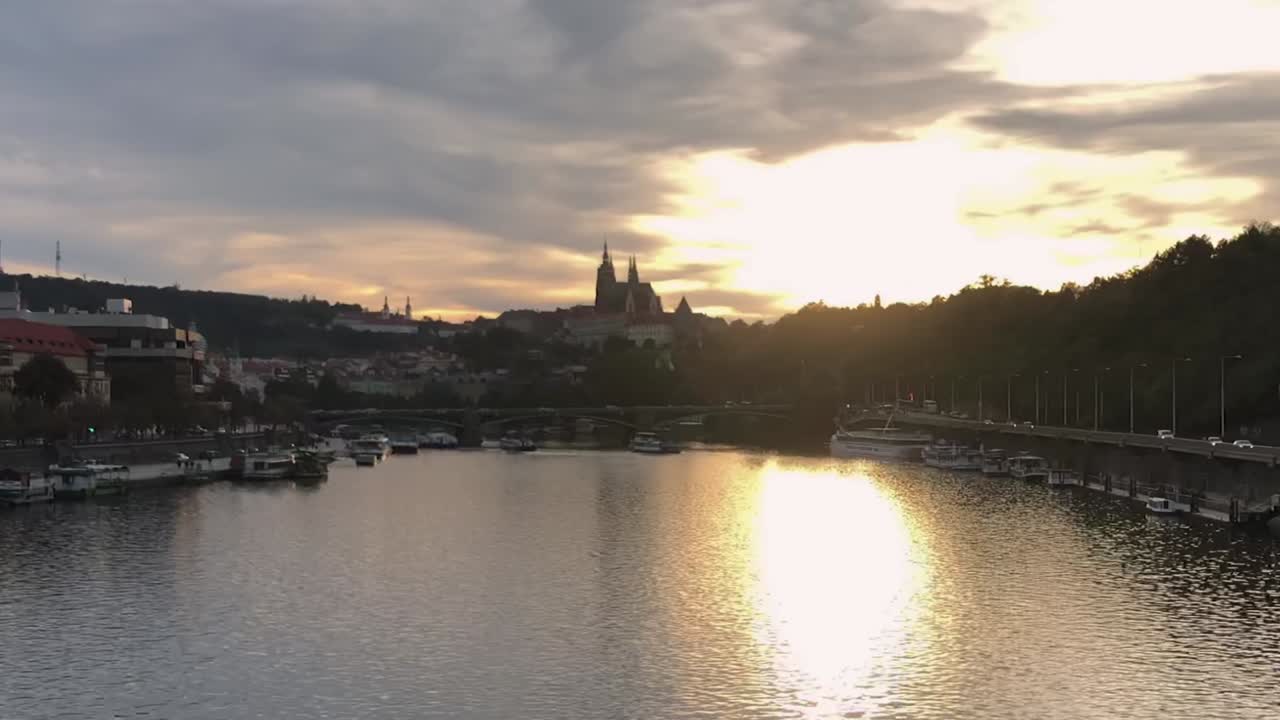 Vista del Castello di Praga dal fiume Moldava mentre un tramonto infuocato illumina il cielo