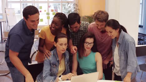 grupo de ejecutivos de negocios discutiendo sobre una computadora portátil en su escritorio
