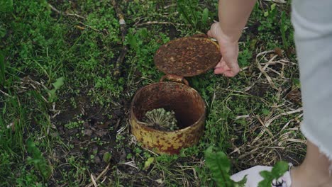the girl closes the air duct opening on the ground with a metal hatch. close-up shooting