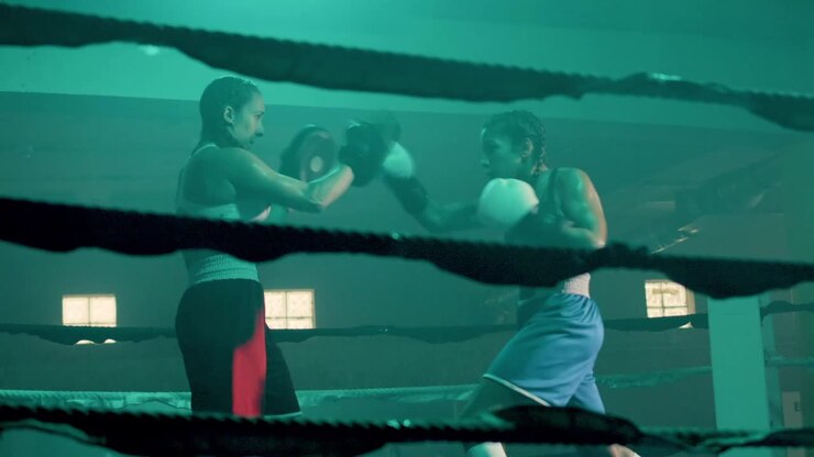 Due pugili donne caucasiche si allenano insieme in una palestra di boxe.