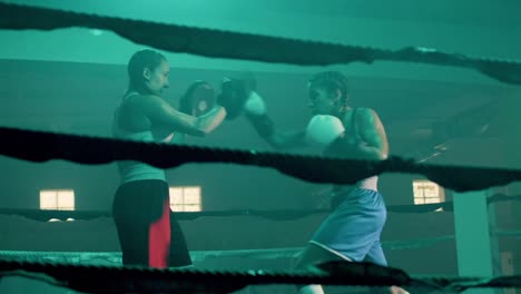 two caucasian female boxers training in boxing gym together