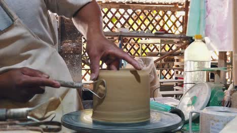 tiro em câmera lenta de um artesão criando uma panela em uma roda de cerâmica no estúdio