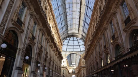push in tilt up wide shot inside of galleria vittorio emanuele ii in milan with the arcades and dome during sunny day