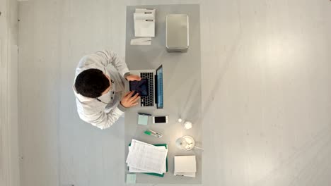 timelapse male doctor working at a table with a laptop. top view