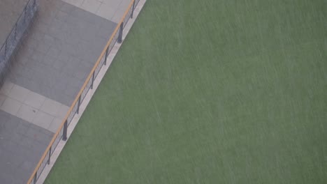 rain on artificial grass in a cityscape