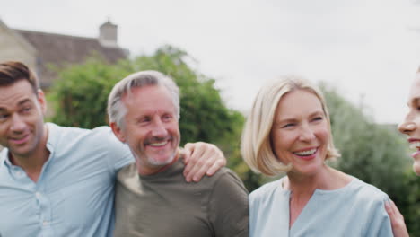 Familie-Mit-älteren-Eltern-Und-Erwachsenen-Nachkommen,-Die-Gemeinsam-Im-Garten-Spazieren-Gehen-Und-Reden