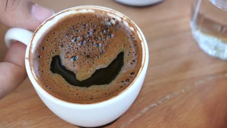 una taza de café turco con una cara sonriente en la parte superior