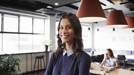 Portrait-of-happy-biracial-casual-businesswoman-in-office,-slow-motion