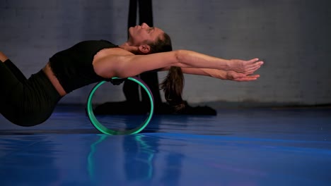 woman using a rolling back cylinder to stretch her back, side shot of person stretching out