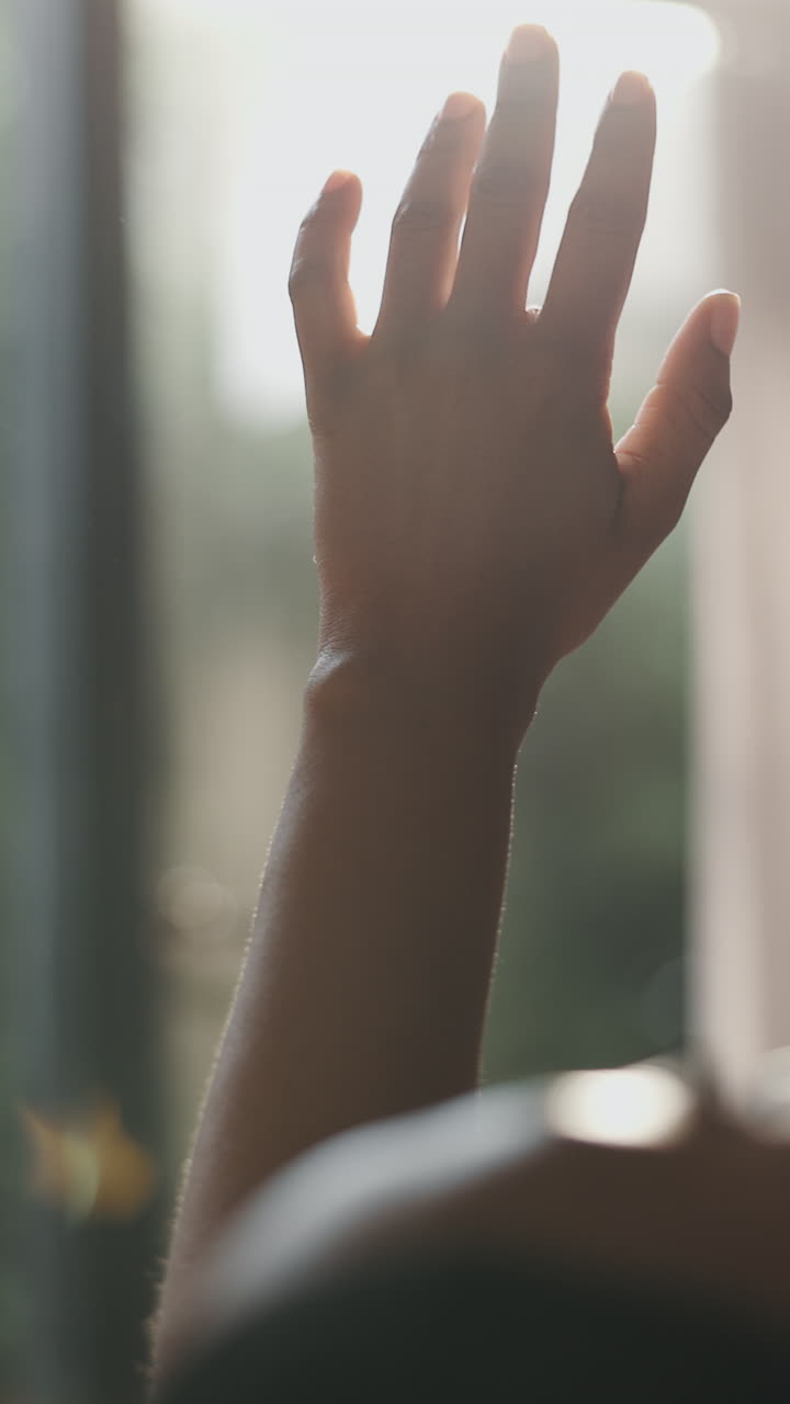 Close-up of Human Hand Reaching Towards Sunlight with Lens Flare