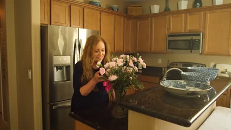 woman walks into kitchen and finds pink rose flowers on the counter