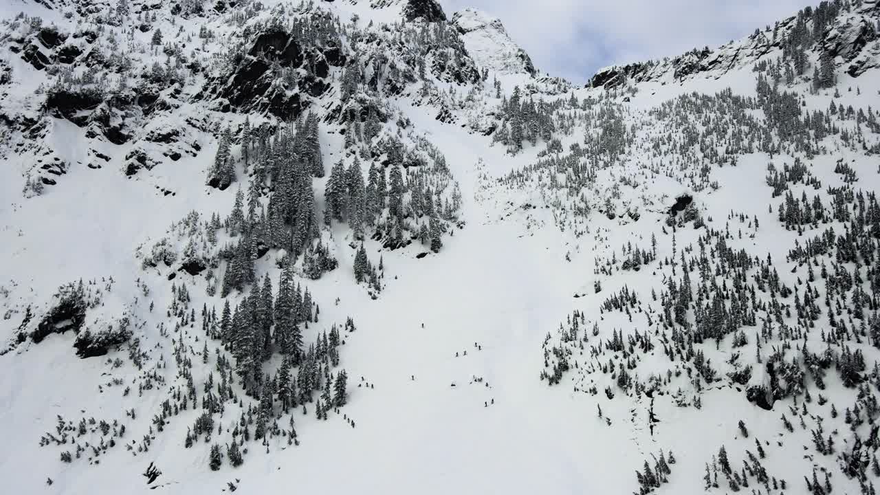 Slow establishing shot of backcountry skiers climbing the Snoqualmie Pass