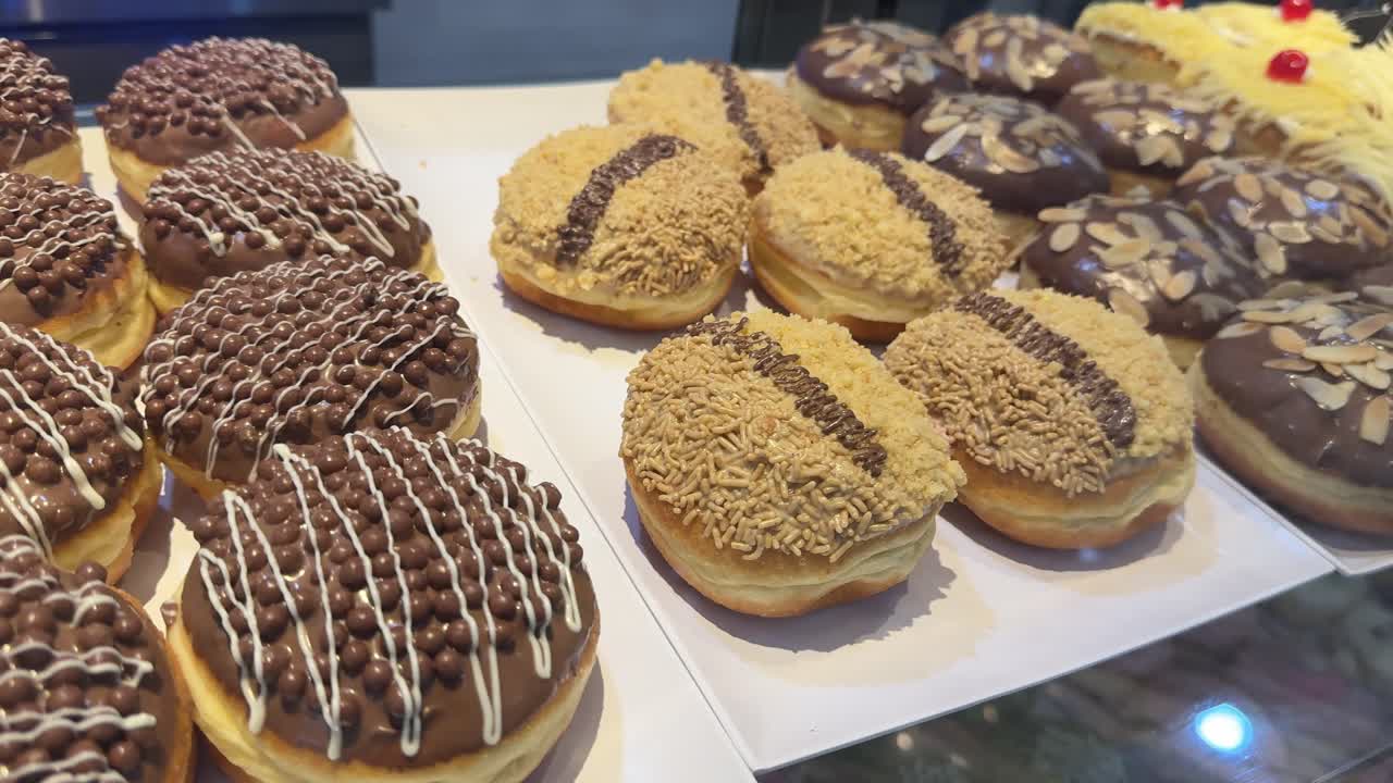 Çeşitli Üst Malzemelerle Sergilenen Lezzetli Glazürlü Donut Çeşitleri