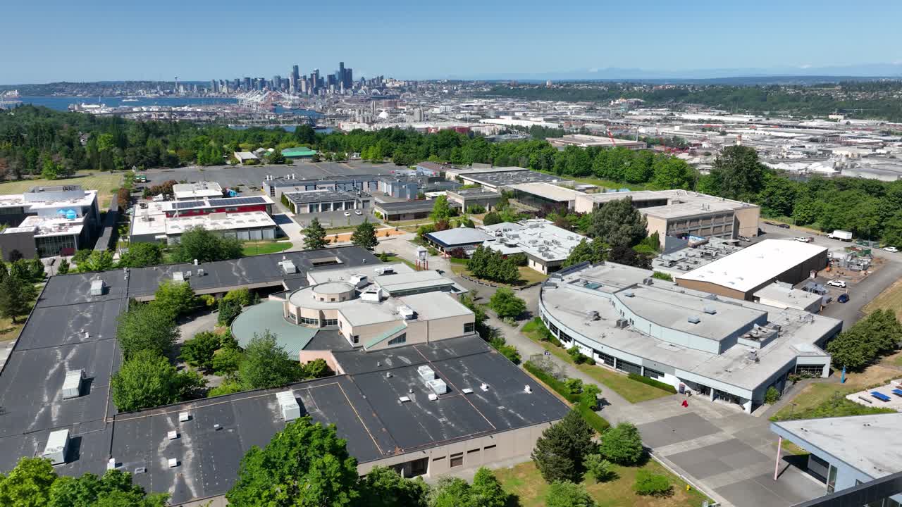 Orbiting aerial view of the South Seattle College campus with Seattle's downtown skyline off in the distance