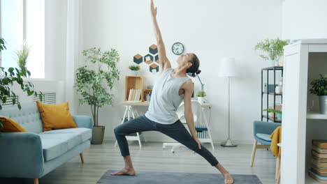 man doing warrior yoga pose at home