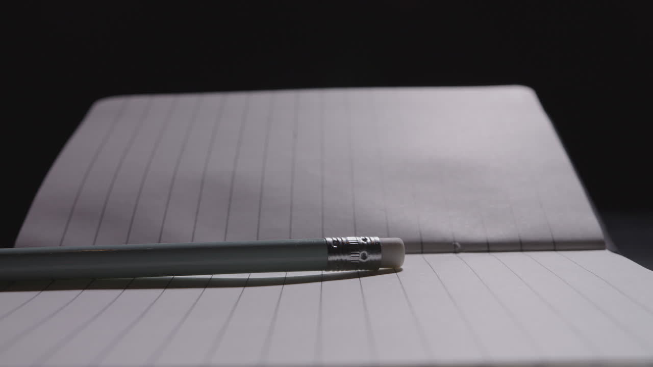 Close up of pencil being slammed down on an open notebook