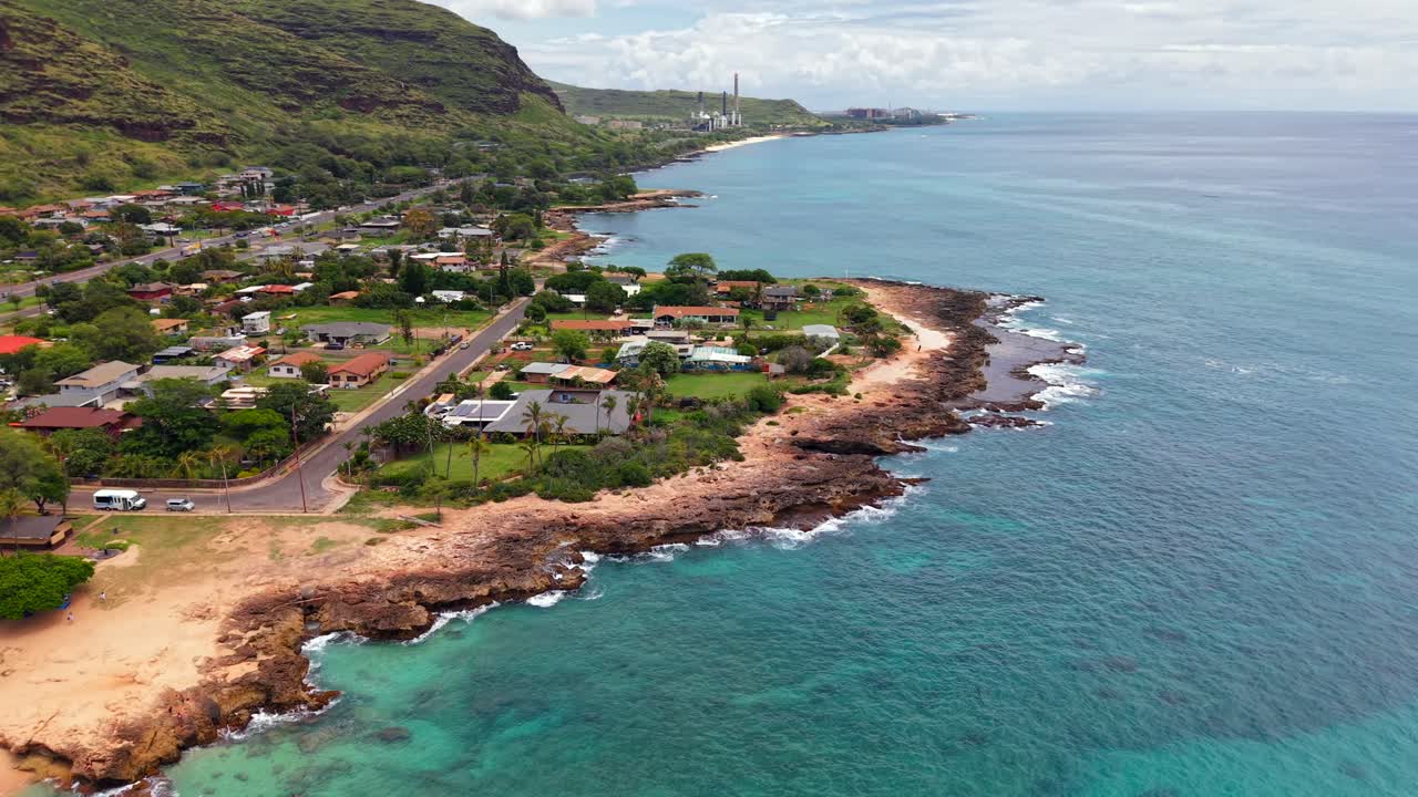 Residential coast of Waianae with Kahe Power Plant in the background in Oahu, Aerial