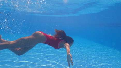 woman diving underwater in a pool