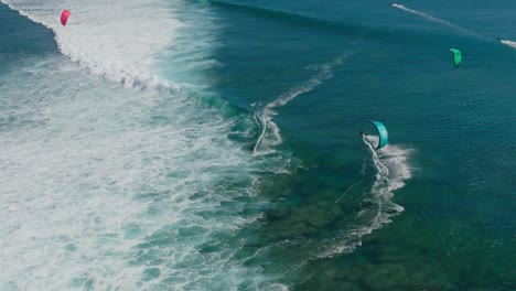 fotografía en cámara lenta de drones de kitesurfistas montando olas en el famoso lugar de un ojo