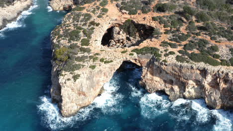 Eroded-rock-cliff-arches-and-cliffs-above-sea-waves-on-Mallorca-coast