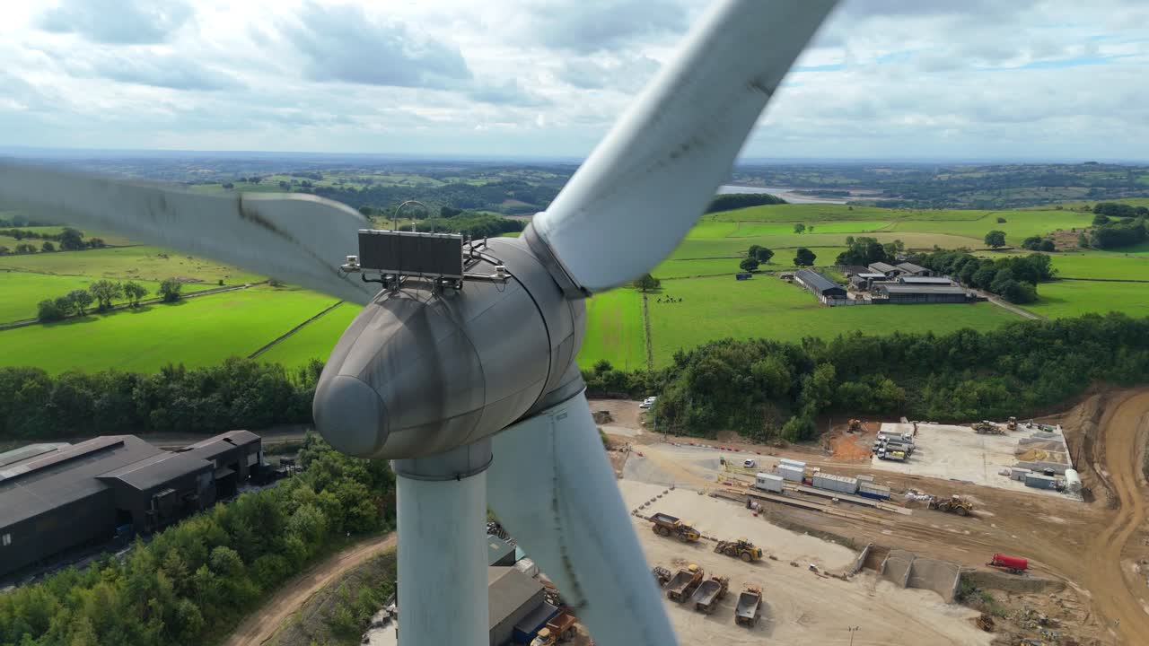 Scenic aerial drone footage of wind turbines and quarry landscape near Carsington Water, Derbyshire Dales, UK, under bright sunny skies