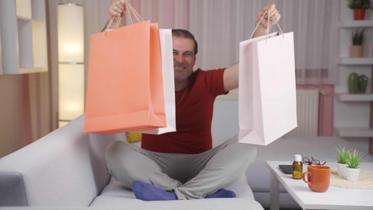 쇼핑백을 들고 카메라를 보는 남자.