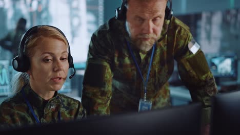 military surveillance officers talking next to a computer screen in central office for cyber operations, control and monitoring for managing national security, technology and army communications.