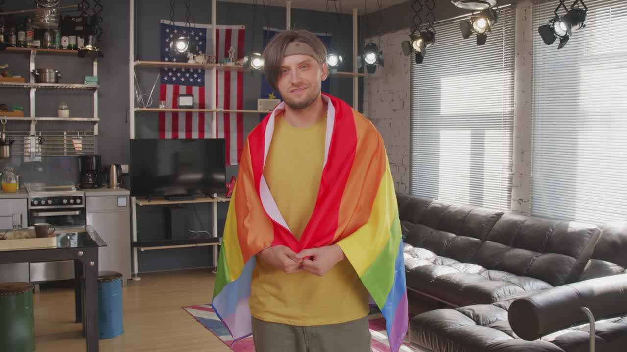 Portrait of Homosexual Man with Rainbow Flag at Home