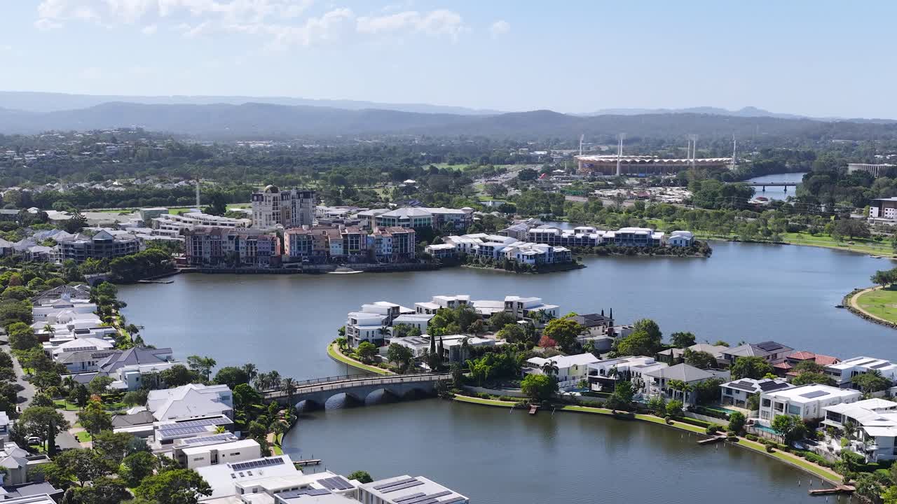Smooth daytime drone pan across Emerald Lakes waterfront housing and surrounding suburban skyline in Australia