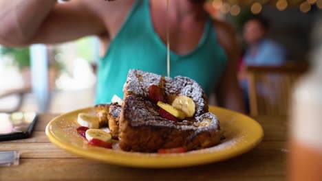 Toma-En-Cámara-Lenta-De-Un-Tipo-Goteando-Miel-Sobre-Frenchtoast-En-Un-Restaurante