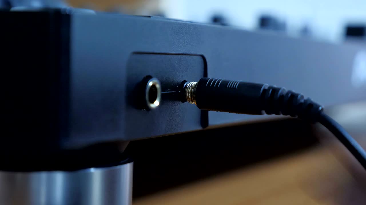 cerca de la mano conectando el cable del micrófono al instrumento