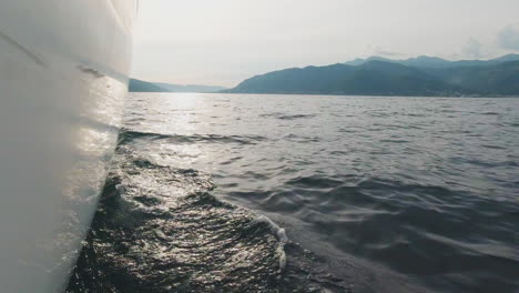 view from a yacht on the sea with mountains in the distance