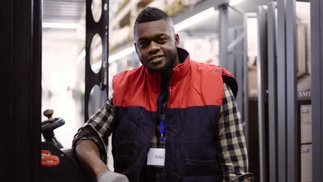 close up portrait of forklift operator in the warehouse, wearing uniform and badge