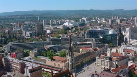 Toma-Aérea-Del-Centro-De-La-Ciudad-De-Novi-Sad-Con-La-Torre-De-La-Iglesia-Del-Nombre-Maria-En-El-Primer-Término