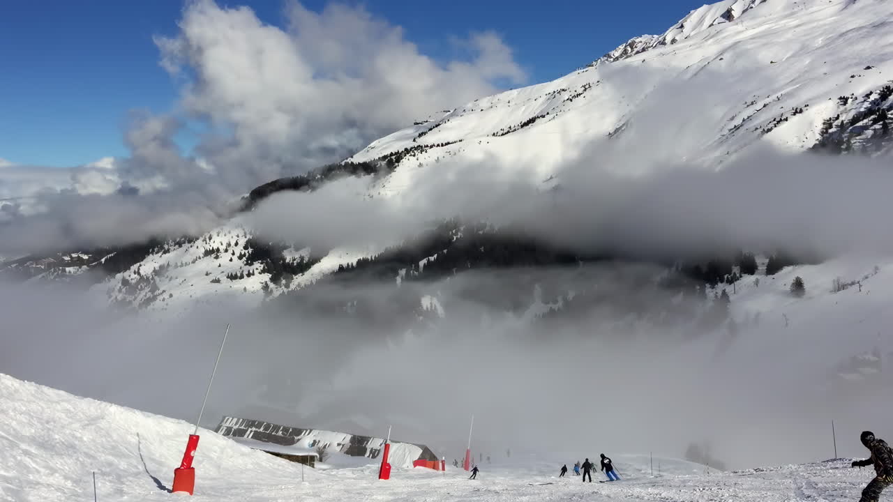 People skiing on the mountains at a ski resort in Les Belleville, France
