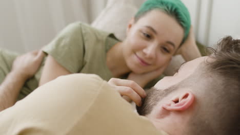 Loving-Woman-Touching-Her-Boyfriend's-Face-While-Relaxing-On-The-Bed-And-Looking-At-Each-Other-1