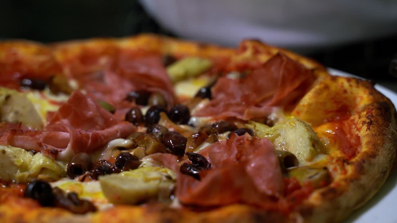 Perfectly good looking delicious pizza getting sliced in slow motion and close up